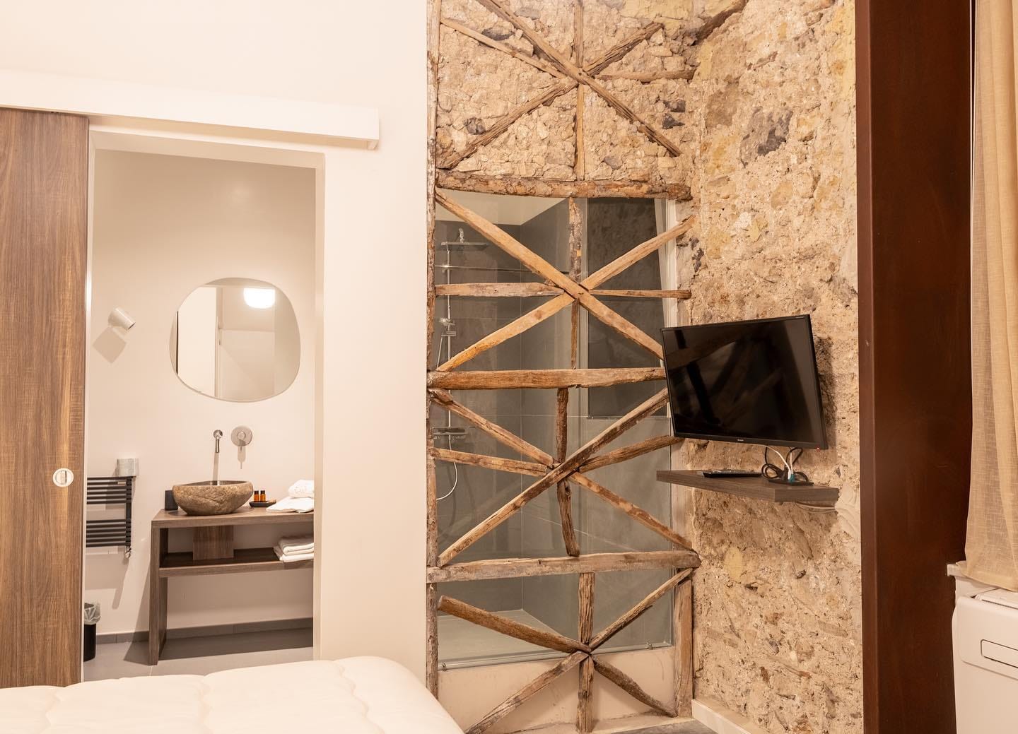 I controventi di legno originali del palazzo, lasciati a vista dietro il vetro della doccia